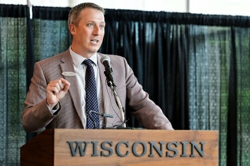 Photo of John Horn speaking at a podium.