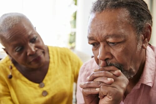 Photo: A concerned woman looking at a troubled man