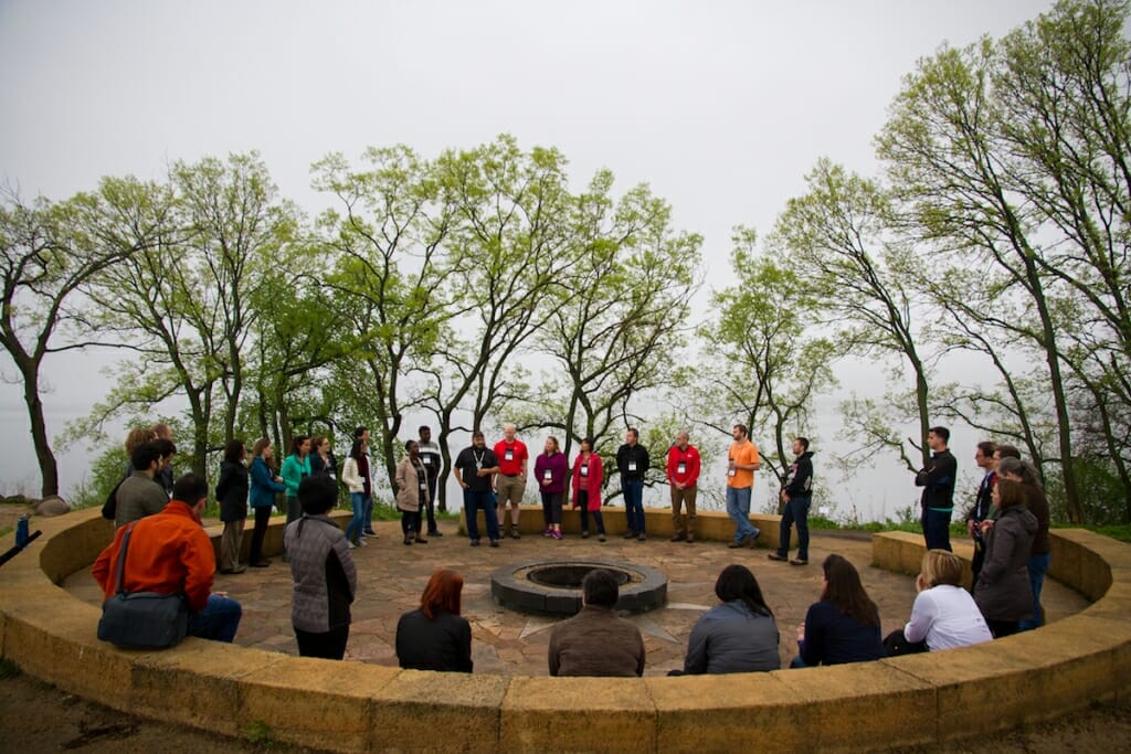 Photo: Group of people standing around fire circle