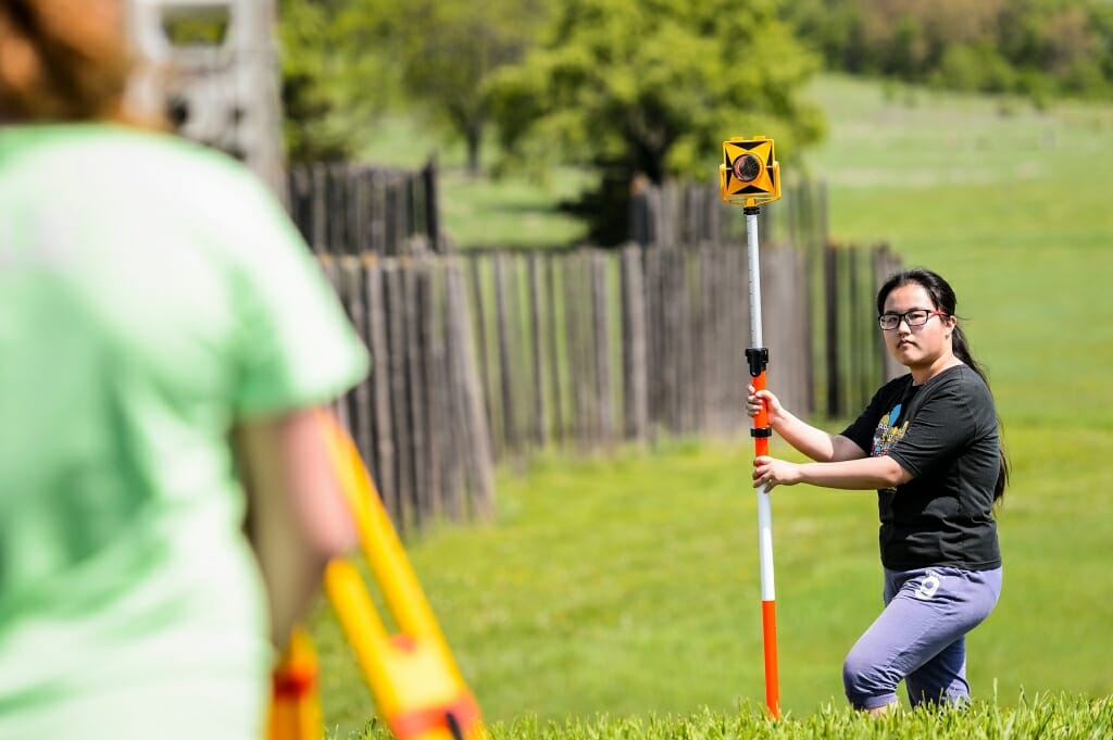 Photo: Student holding survey camera on pole