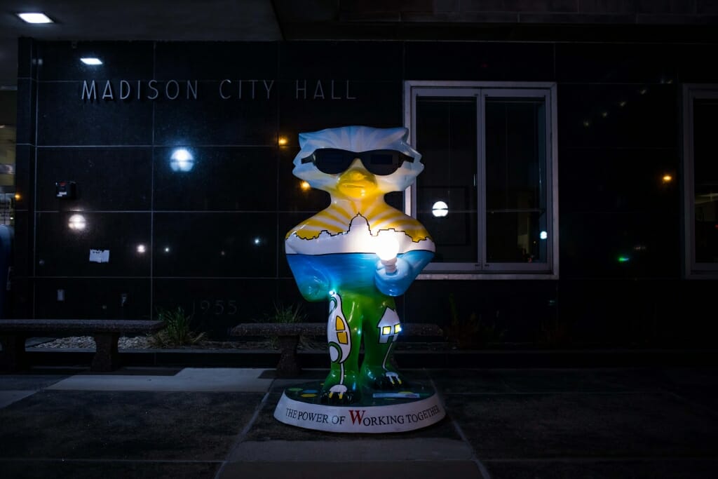 A photo of "Bucky Energized" photographed at night. The statue, also designed by Hustad, is sponsored by Madison Gas and Electric and features a functional flashlight gripped in Bucky's paw. 