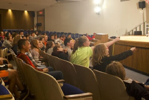 Photo: Students in auditorium pointing at stage