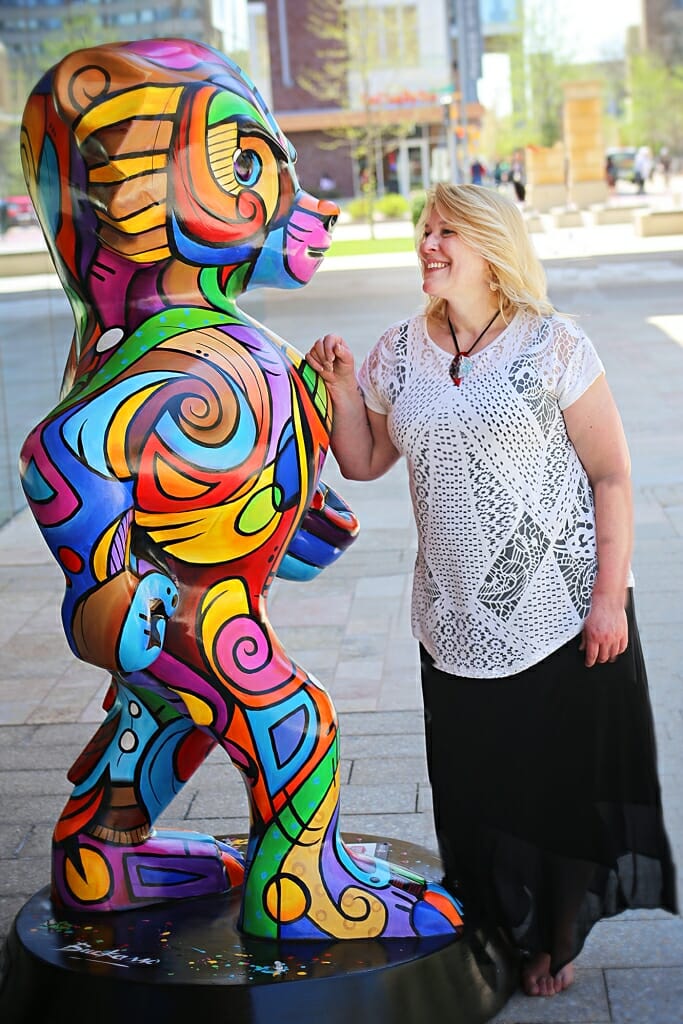 Photo of Artist Julie Hustad standing next to "Bucky come se Picasso," an homage to Picasso's cubist paintings she designed for Bucky on Parade, a public art project. 