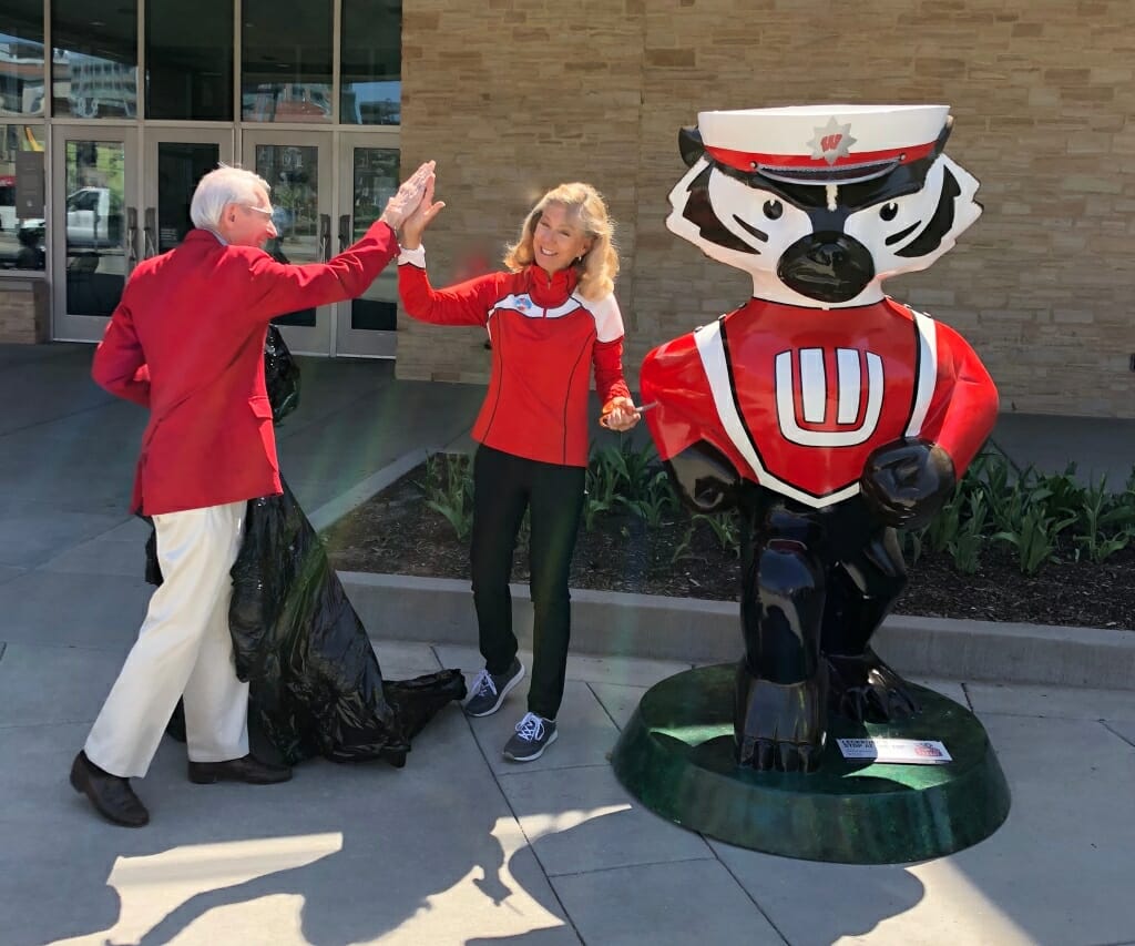 Mike Leckrone and Burgess celebrating next to the Bucky Badger statue after unveiling it.