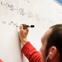 Photo: Person writing on whiteboard