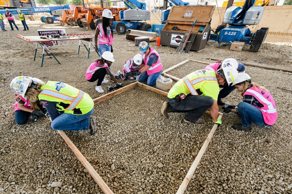 The girls learn to build a cement form in preparation for pouring concrete.