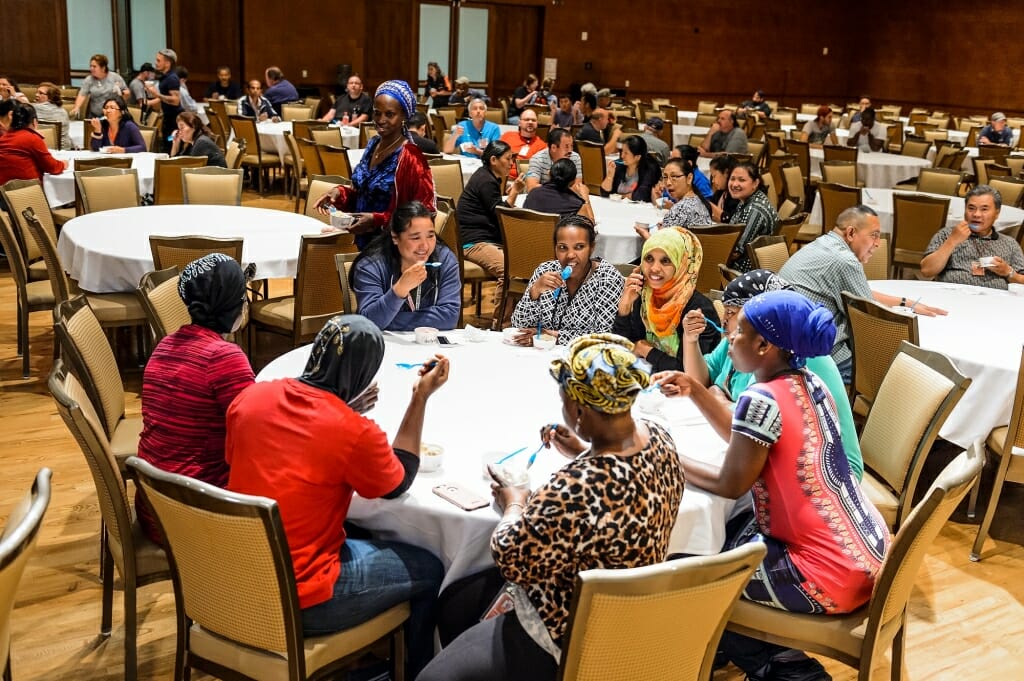 Photo: People sitting at round tables eating ice cream and talking