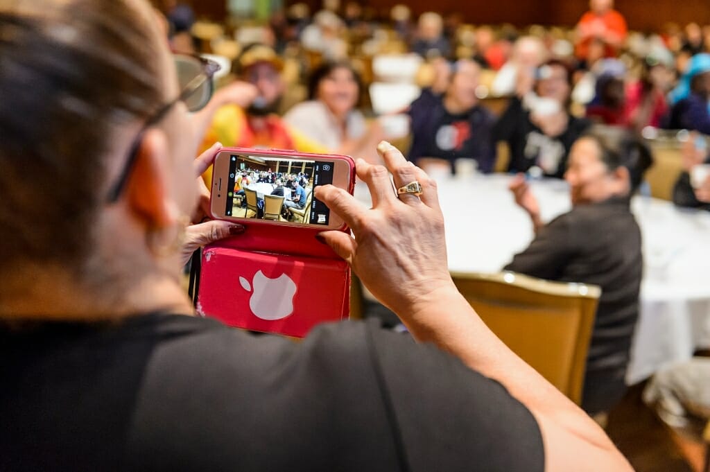 Photo: Person taking cellphone picture of crowd