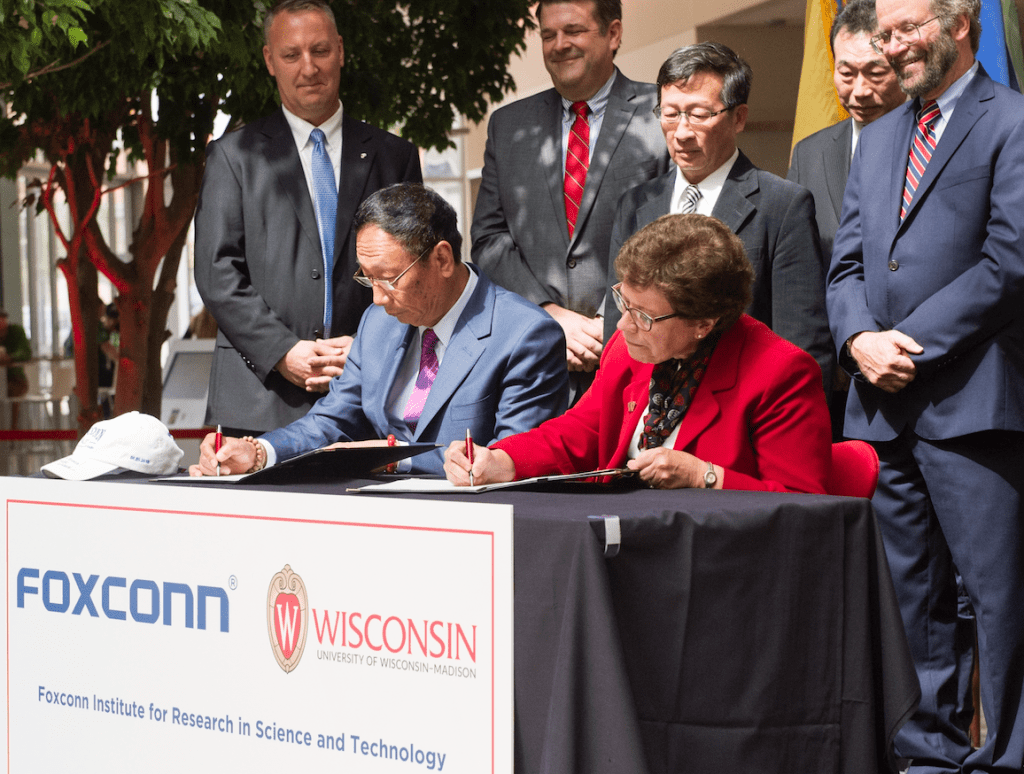 Photo: Gau and Blank sitting at table signing documents