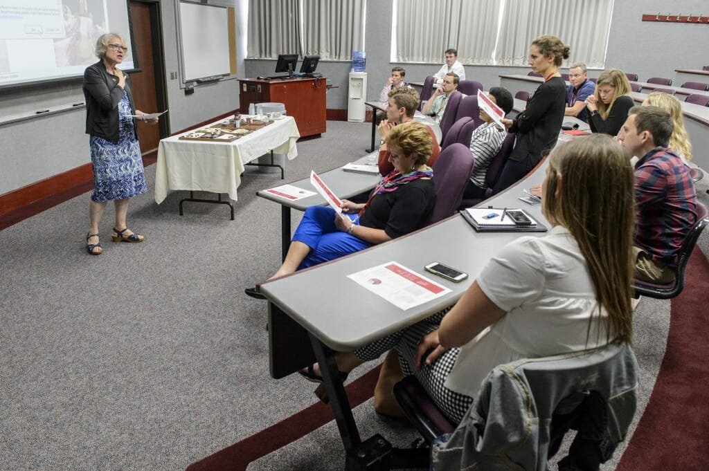 Photo: VandenBosch speaking to small group of seated people in a classroom