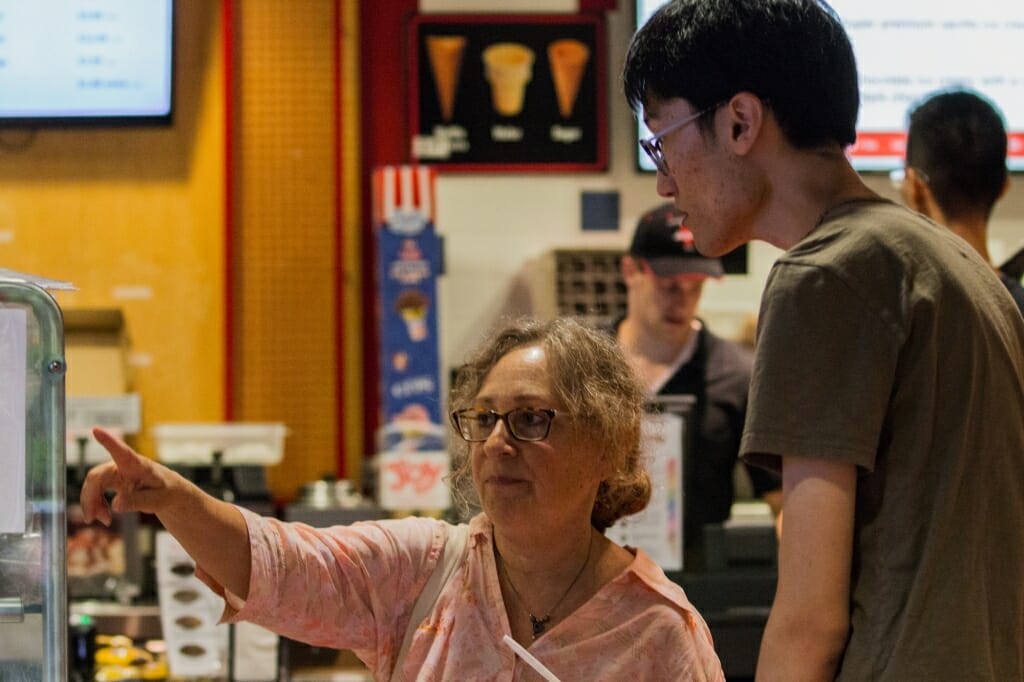 Andrea Poulos, a teacher in the International Student Summer Institute, helps student Hyecheol Jang, Pusan, South Korea, read about the variety of cheeses produced at Babcock Hall.