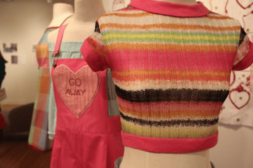 A red, beige and green striped sweater on a mannequin