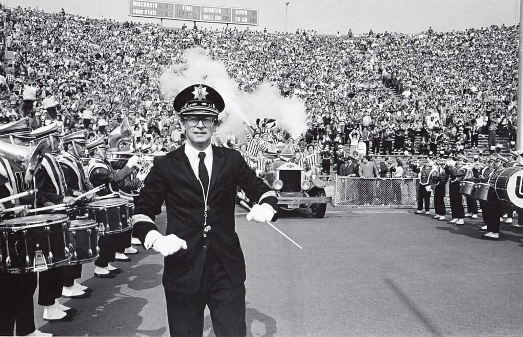 Photo: Leckrone conducting while Bucky Wagon enters stadium behind him