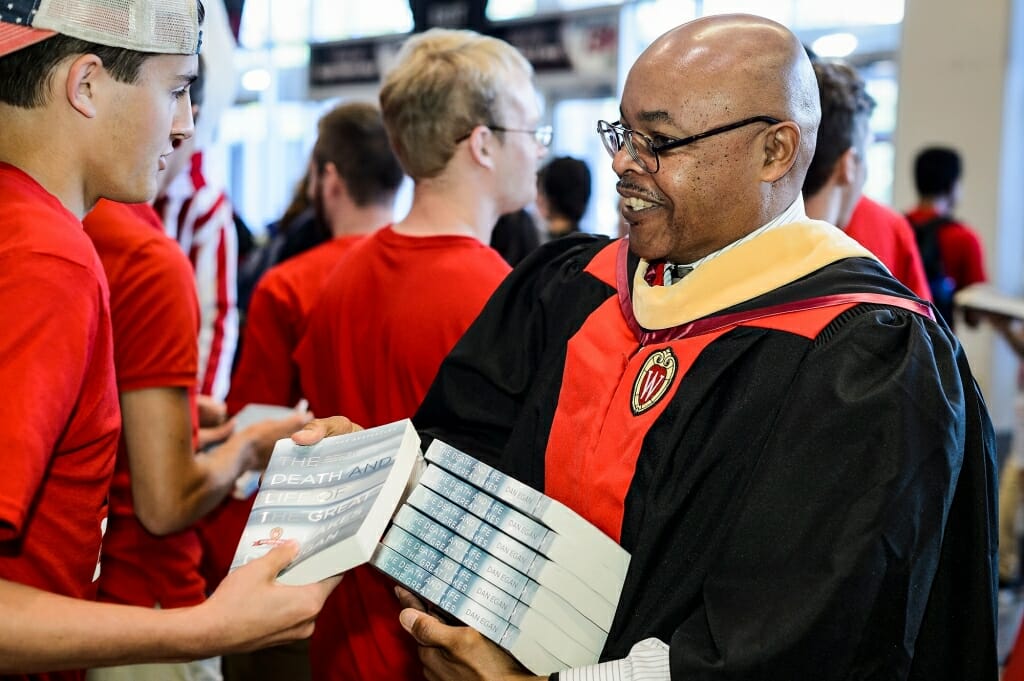 André E. Phillips, Director of Admissions and Recruitment, helps volunteers distribute  