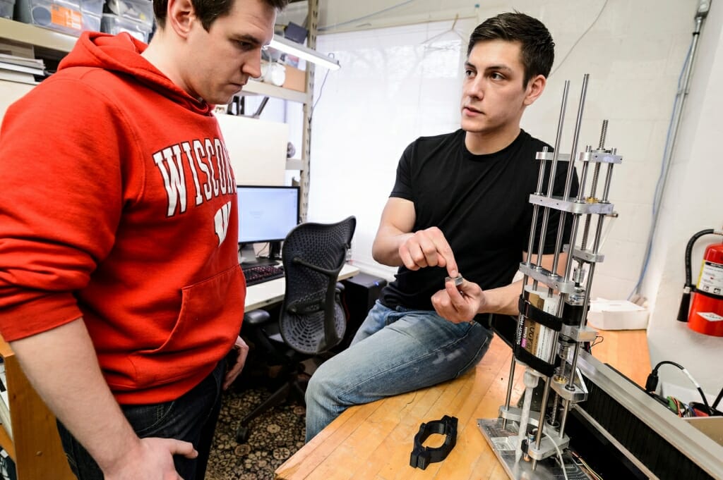 Photo: 2 men at a lab bench with device on it