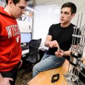 Photo: 2 men at a lab bench with device on it