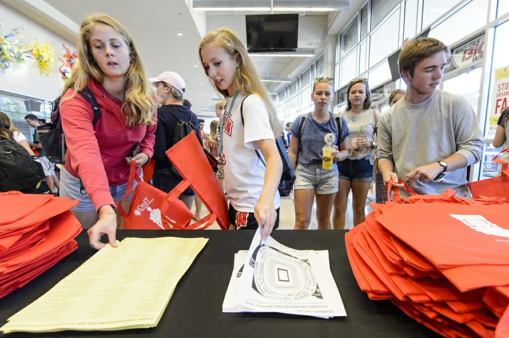 Students pick up an event map and booth list.