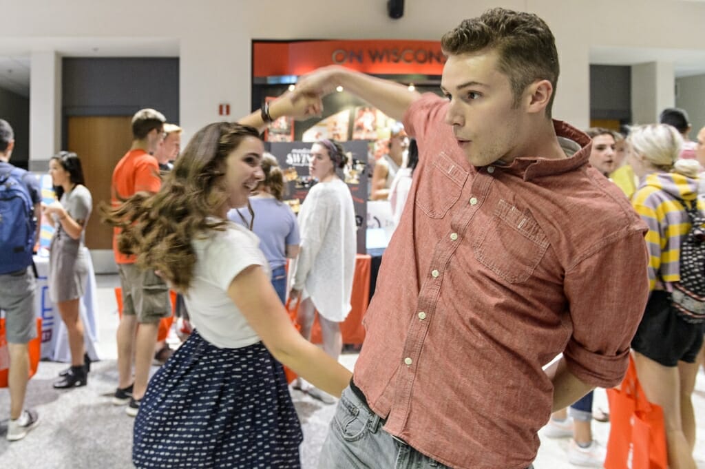 Amy Lossen (left) and Tony Feller (right) give a demonstration near Madison Swing dance club booth.