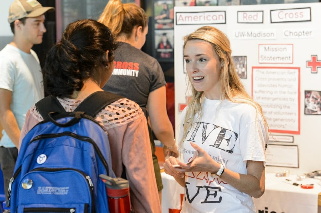 Carly Langkamp (right) speaks to a student about the UW American Red Cross Club.