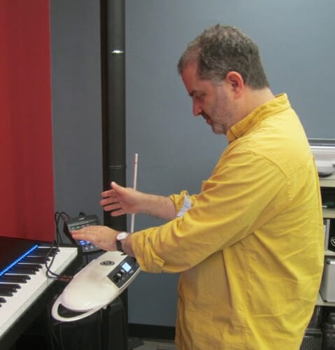 Photo: Professor standing in front of keyboard with theramin