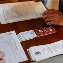 Voter registrations forms are filled out at a table.