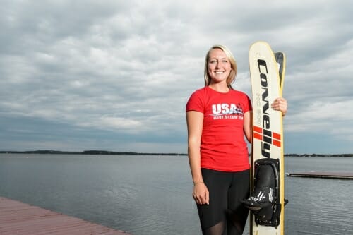 Gabbie Taschwer stands on a dock, holding her water skis, with Lake Mendota in the background.