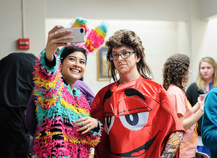 Two residents take a selfie for Halloween. One is dressed as a pinata and the other is dressed as an M&M. 