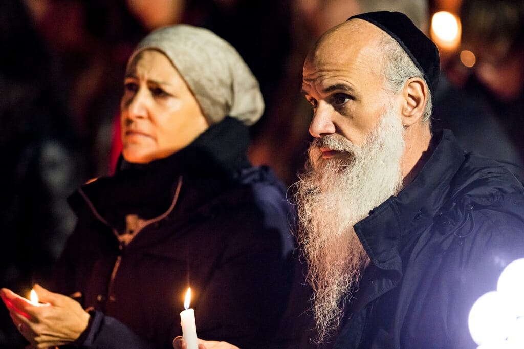 Photo of Rabbi Gairshon Vogel holding a candle.