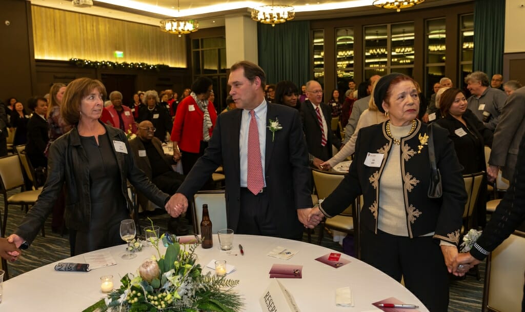 Photo: People standing, clasping hands