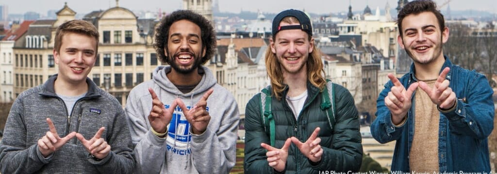 Photo of four students flashing the W hand sign.