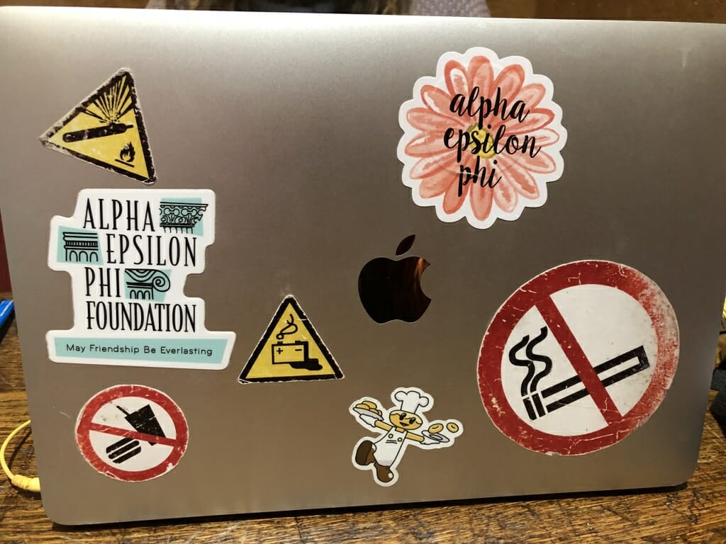 First year graduate student Kate Melberg's laptop, which features a No Smoking sticker, two referencing her sorority, and a sticker from a donut shop in Ohio. 