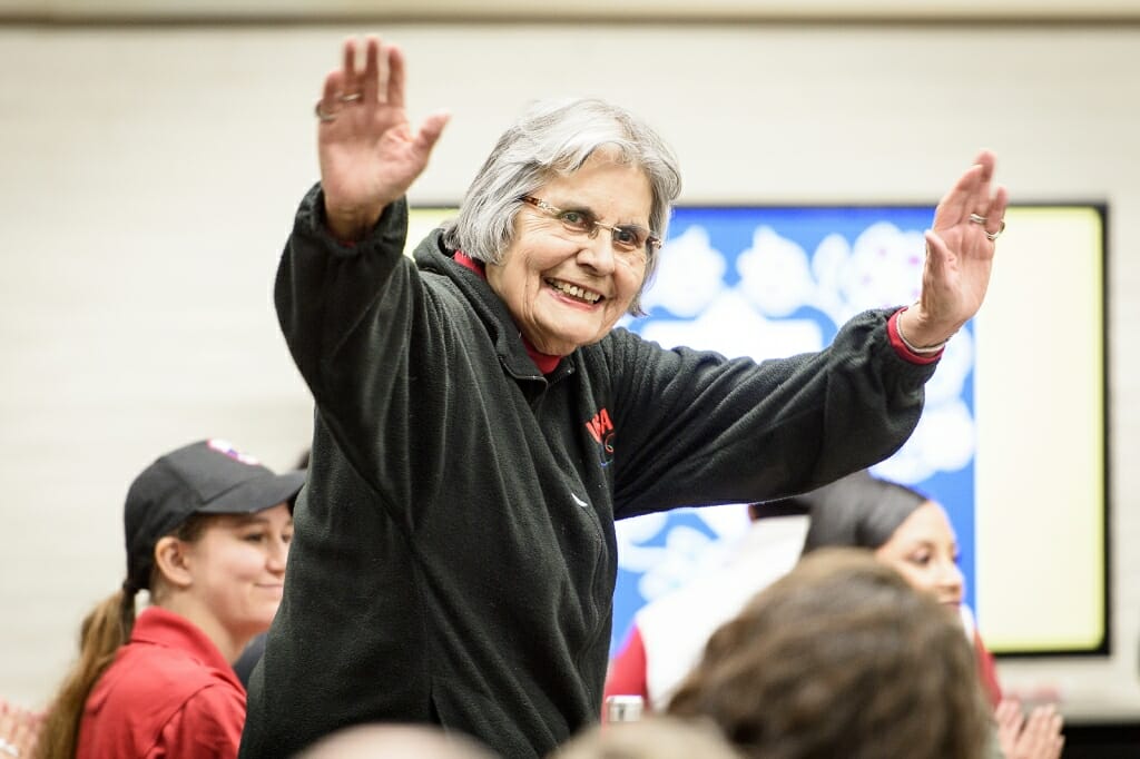 Ada Deer raises her hands in greeting to the students.