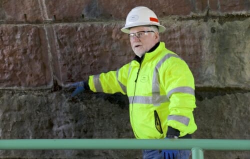 Photo: Inspector in hardhat pointing out damage