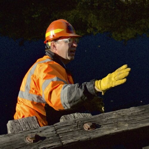 Photo: Man in hardhat standing under rails