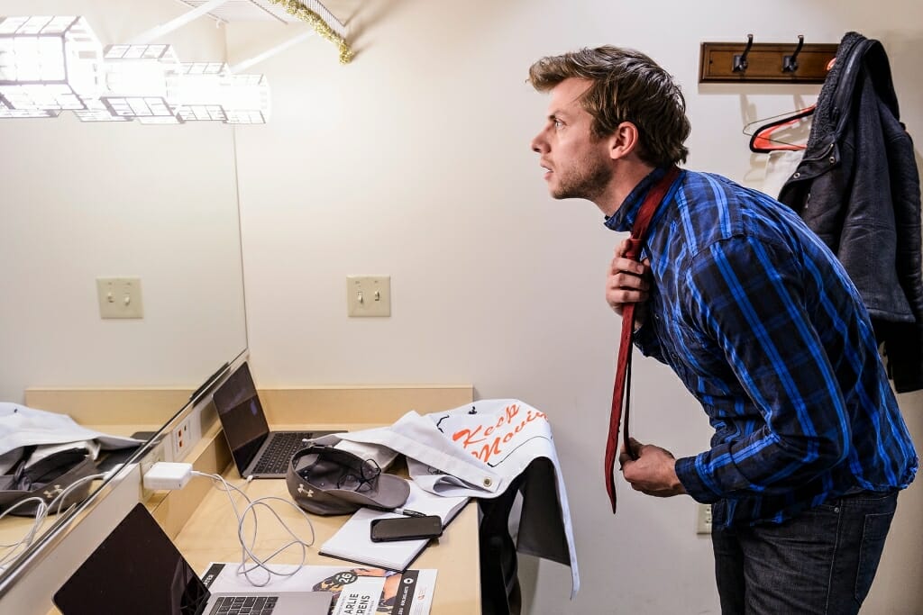 Photo: Berens adjusting necktie in mirror