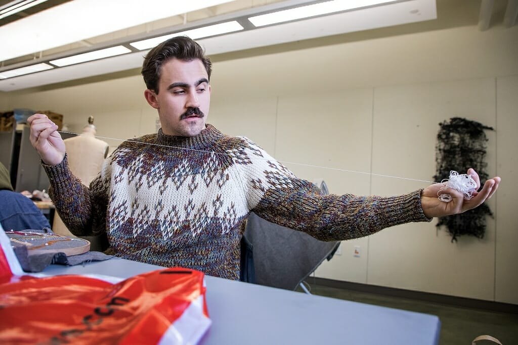 Photo: Man stretching a piece of thread