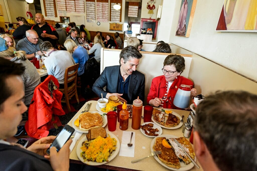 Photo: David Muir and Rebecca Blank sitting in restaurant booth with plates of food