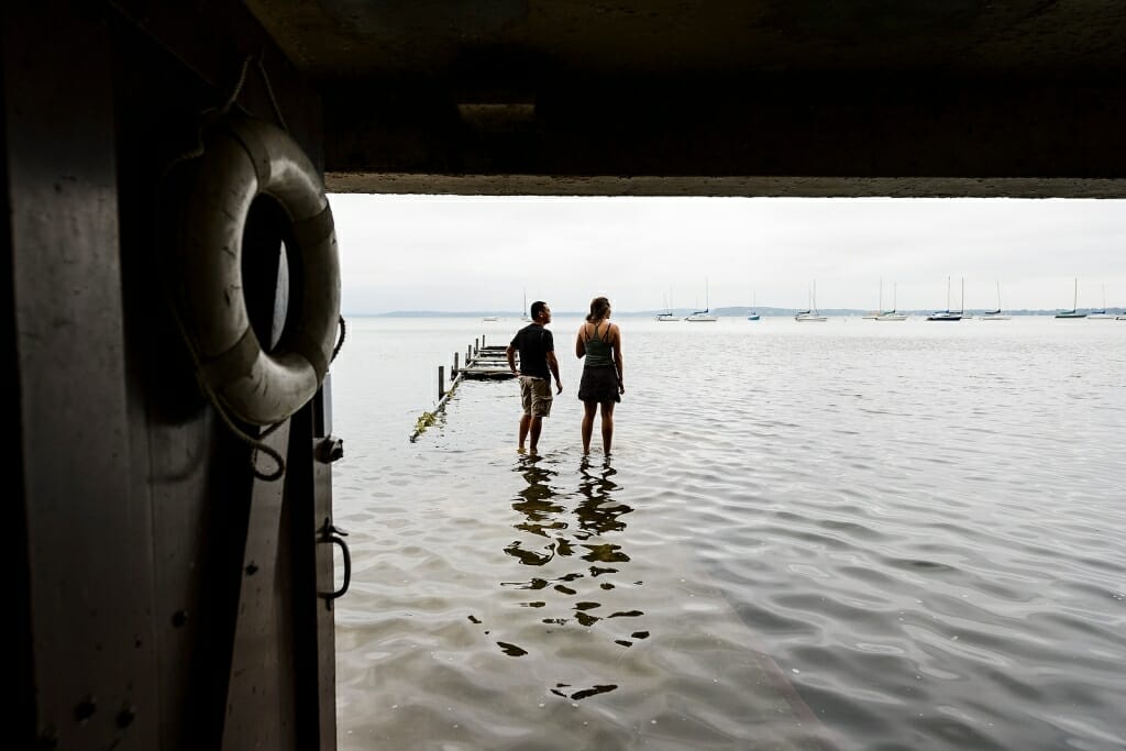 Photo: Two people standing on a partially submerged pier