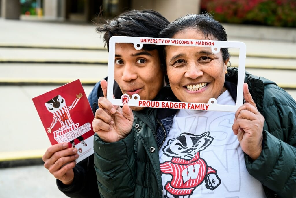 Photo: Two people looking through a license plate housing