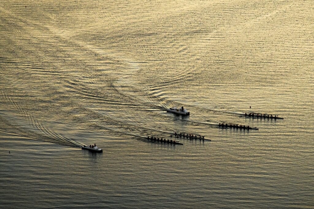 Photo: Aerial view of boats in water making ripples