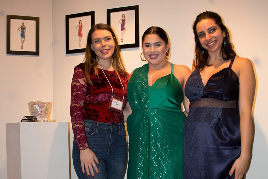 Photo: Three women, two of them modeling dresses designed by the other.