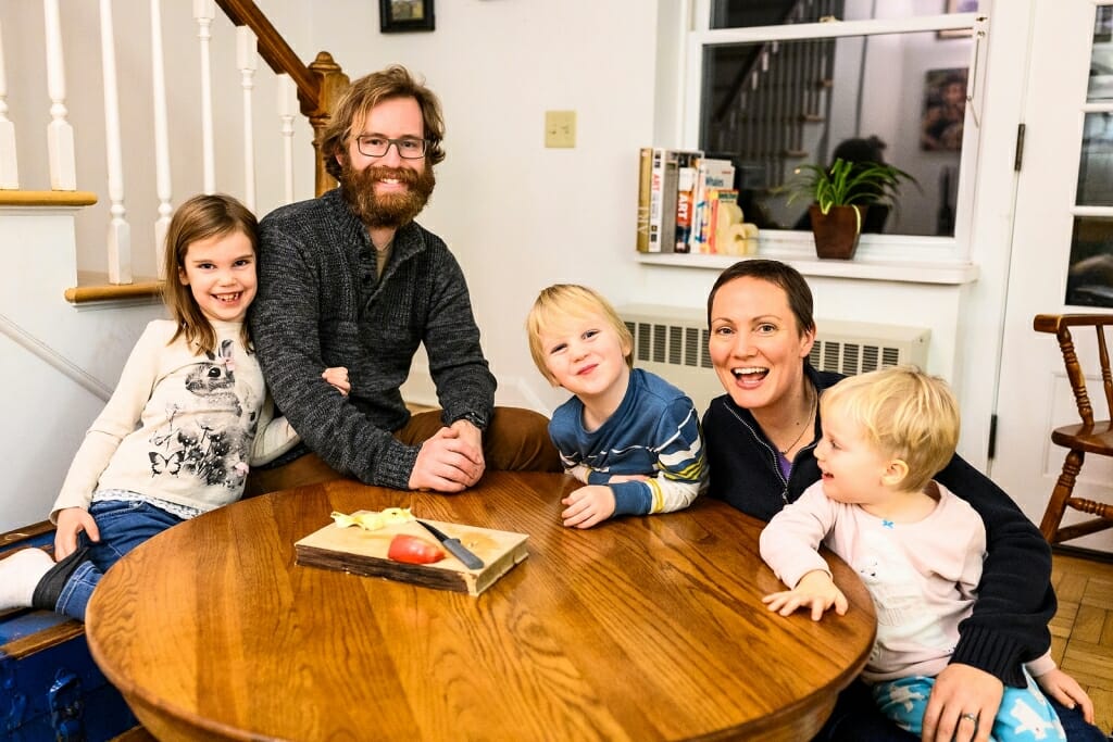 Photo of Noah and Noel Ash and their three children gathered around a table.