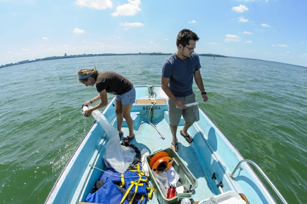 Photo: Walsh and Brosat on a boat, dipping nets into water