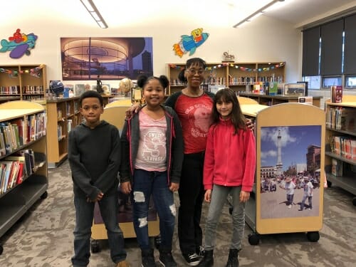 Some kids pose in a library.