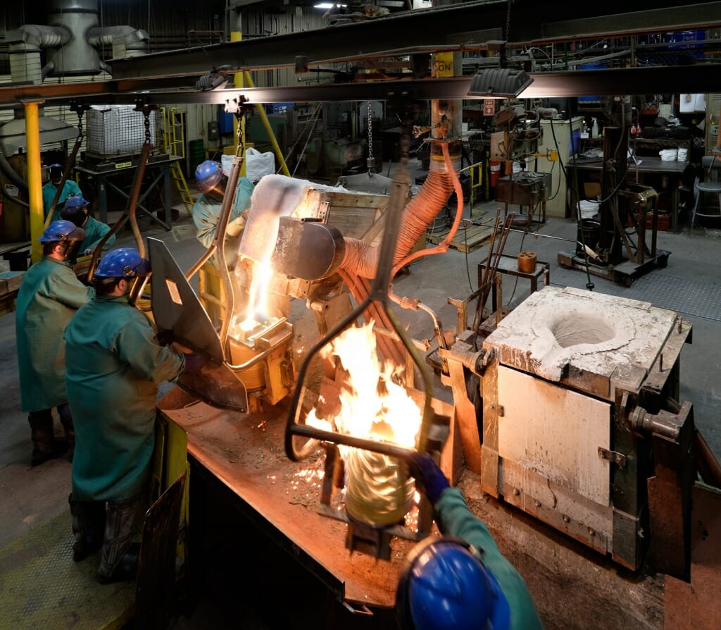 Photo: Workers pouring molten metal in foundry