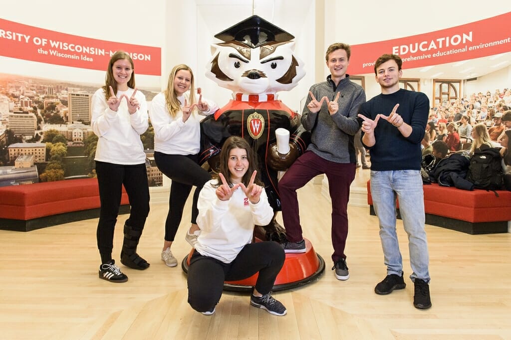 Five people in front of a Bucky Badger statue.