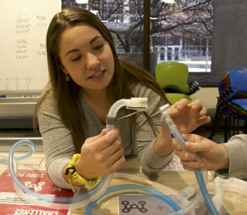 Photo: Margaret Edman connects two plastic tubes.