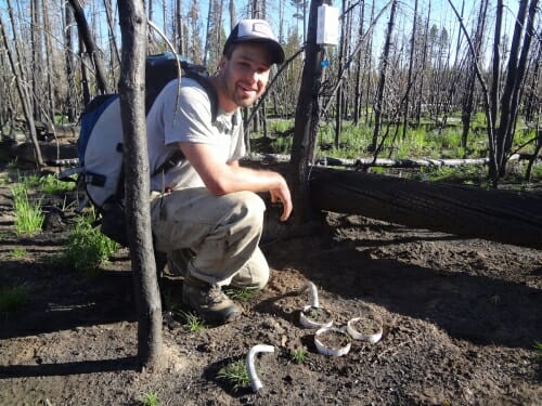 Photo: Hansen squatting on ground in forest