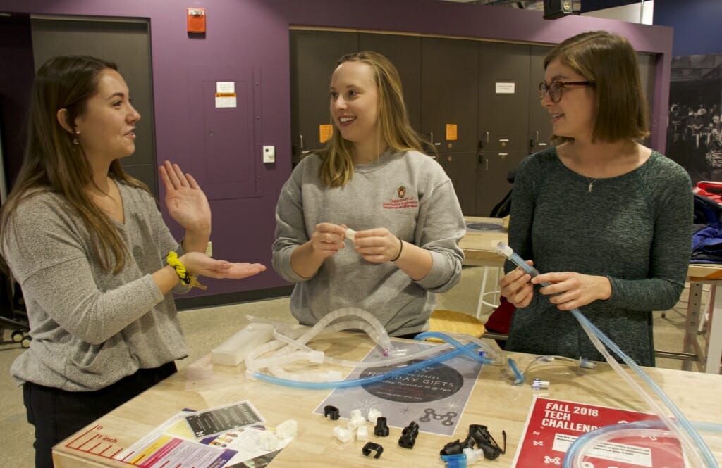 Photo: Three biomedical engineering students show off their invention.