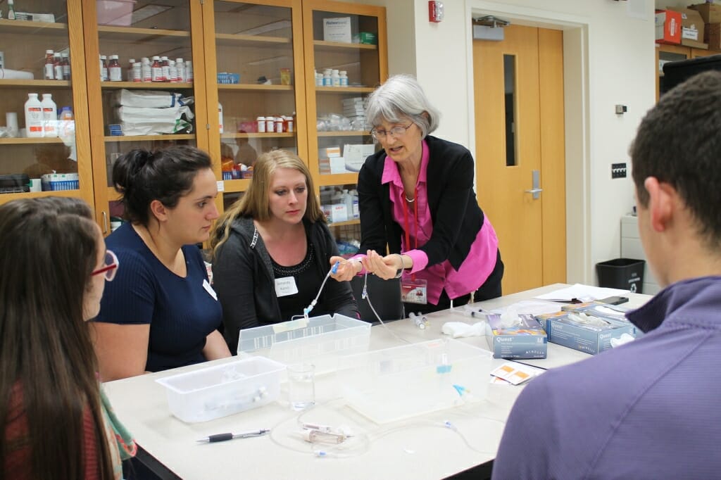 Photo: Professor works with pharmacy students.